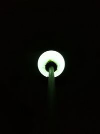 Low angle view of illuminated lamp against black background