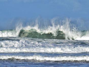 Sea waves splashing against sky