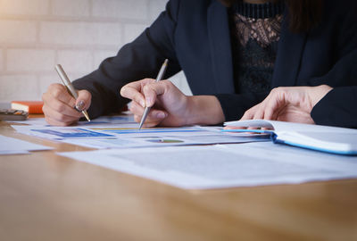 Midsection of woman using laptop on table