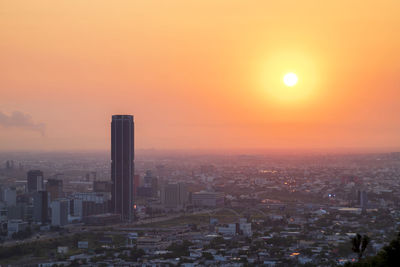 High angle view of modern buildings against sky during sunset