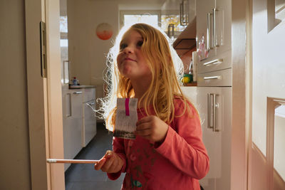 Girl holding ice cream at home