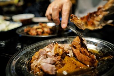 Close-up of person preparing food in plate