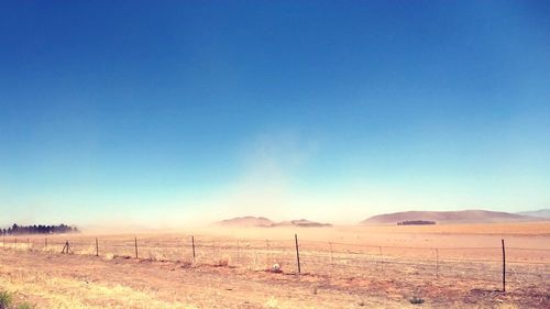 Scenic view of desert against clear blue sky