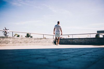 Rear view of man walking on building terrace