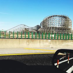 View of a.n abandoned  wooden coaster against blue sky