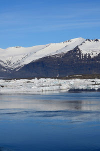 Snow and ice capped mountains surrounding a lagoon in the south of iceland.