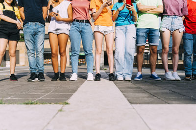 Friends standing together on footpath