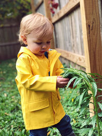 Portrait of cute boy looking away while standing outdoors