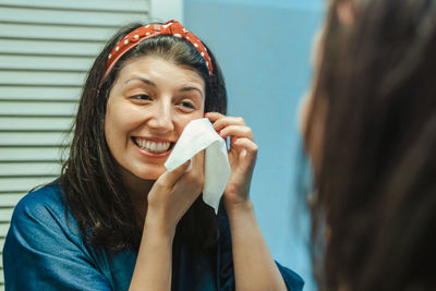 Portrait of a smiling young woman holding camera