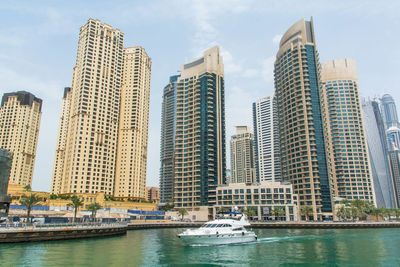 Modern buildings at waterfront against sky