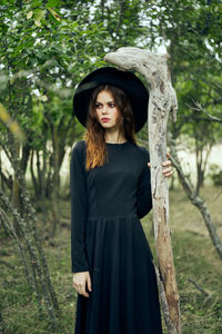 Portrait of young woman standing in forest