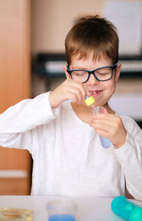 Boy is engaged in scientific research. a child with a test tube and a pipette in his hands. 