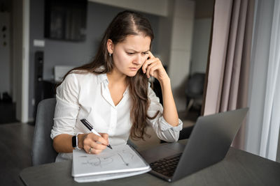 Young woman using laptop at home