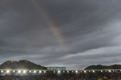 Low angle view of illuminated rainbow over buildings in city