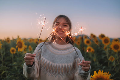 Young woman blowing bubbles against sky