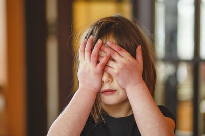 Close-up portrait of a girl covering face