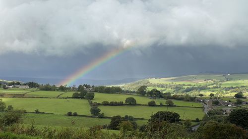 Scenic view of rainbow over landscape against sky