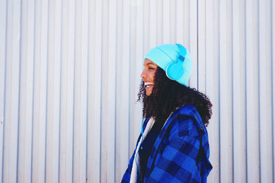 Side view of woman standing against wall