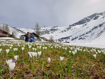 Rear view of man sitting on snow covered land