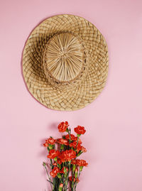 Vintage hat on pink background with flower bouquet