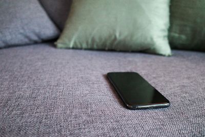 Close-up of mobile phone on sofa
