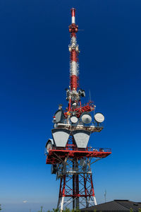 Low angle view of communications tower against blue sky