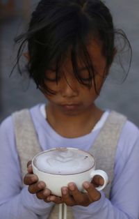 Close-up of girl holding coffee cup