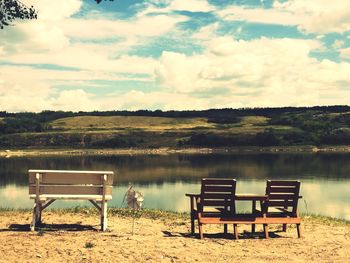 Rear view of empty chairs on landscape against sky