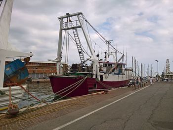 Ship moored at harbor against sky