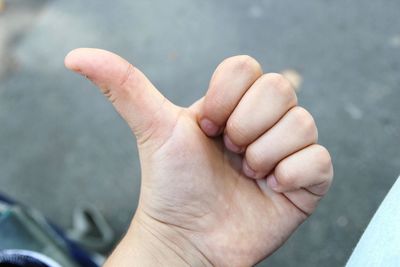 Cropped image of hand gesturing thumbs up sign