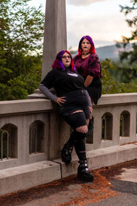 Low angle view of woman standing on footpath
