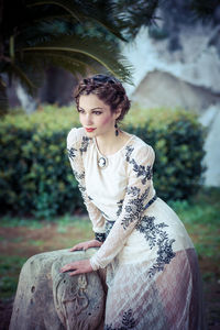 Portrait of young woman sitting outdoors