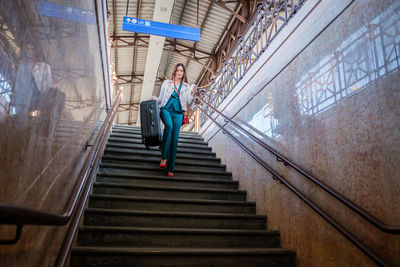 Rear view of man walking on escalator