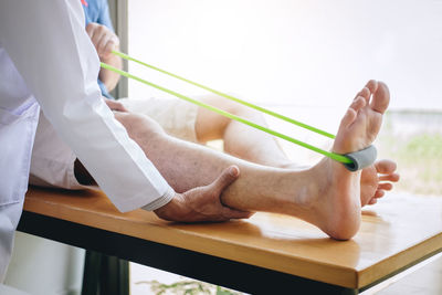 Low section of man with hands on table