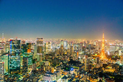 High angle view of illuminated buildings against clear sky at night