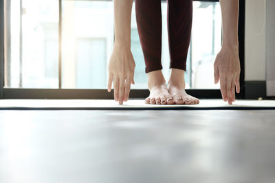 Low section of woman doing yoga in studio