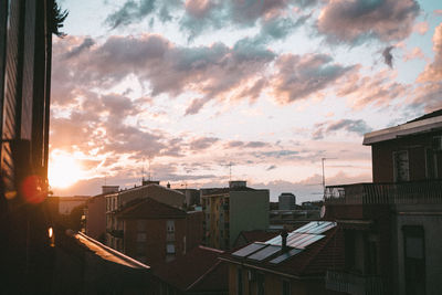 Buildings in city against sky during sunset