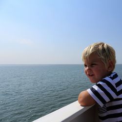 Side view of woman looking at sea against clear sky