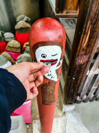 Midsection of person holding red while standing outdoors