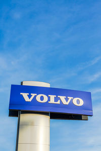 Low angle view of road sign against blue sky