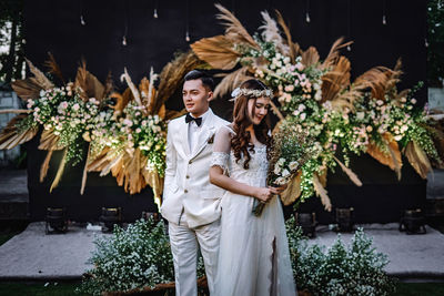 Woman standing by potted plants - indonesian wedding