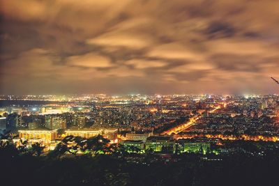 Illuminated cityscape against sky at night