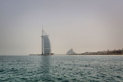 Building by sea against clear sky