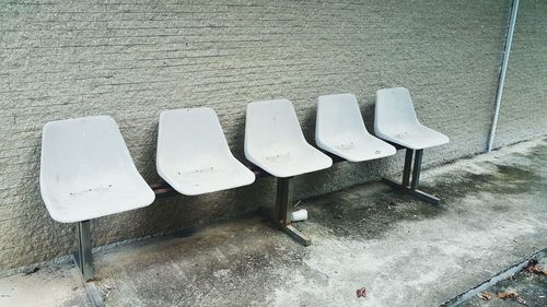 High angle view of empty chairs against wall
