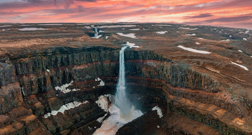 Aerial view on hengifoss waterfall with red stripes sediments in iceland.