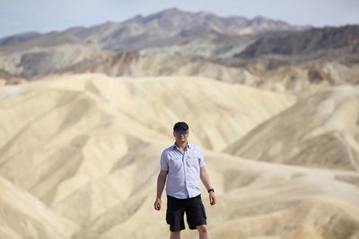 Portrait of young man standing on desert