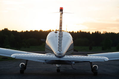 Airplane on airport runway against sky