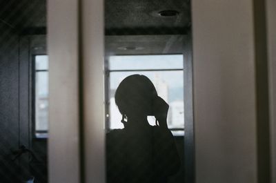 Silhouette of man on window