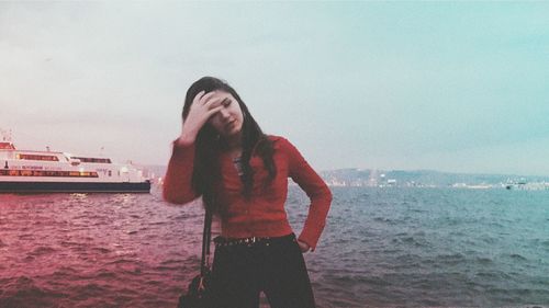 Woman standing by sea against sky