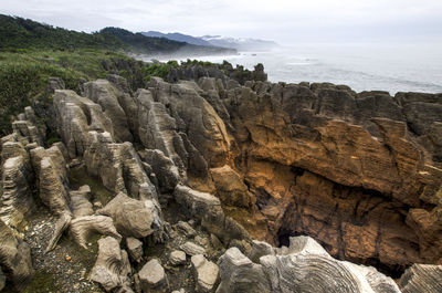 Scenic view of rock formations by sea